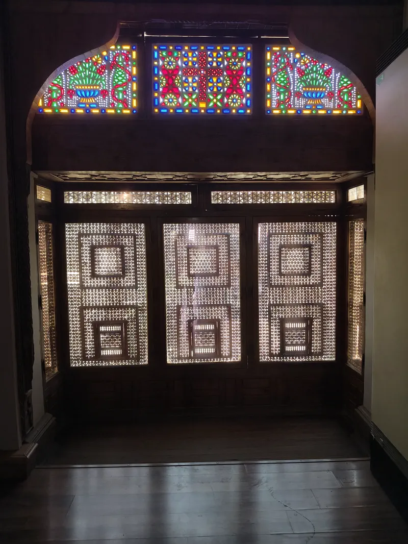 Colorful stained glass detail above carved wooden panels