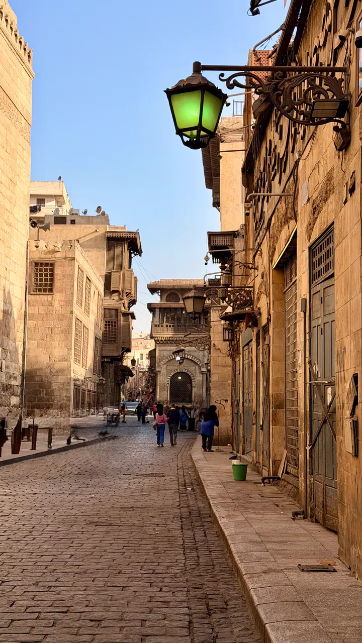 People walking through a sunlit Historic Cairo street